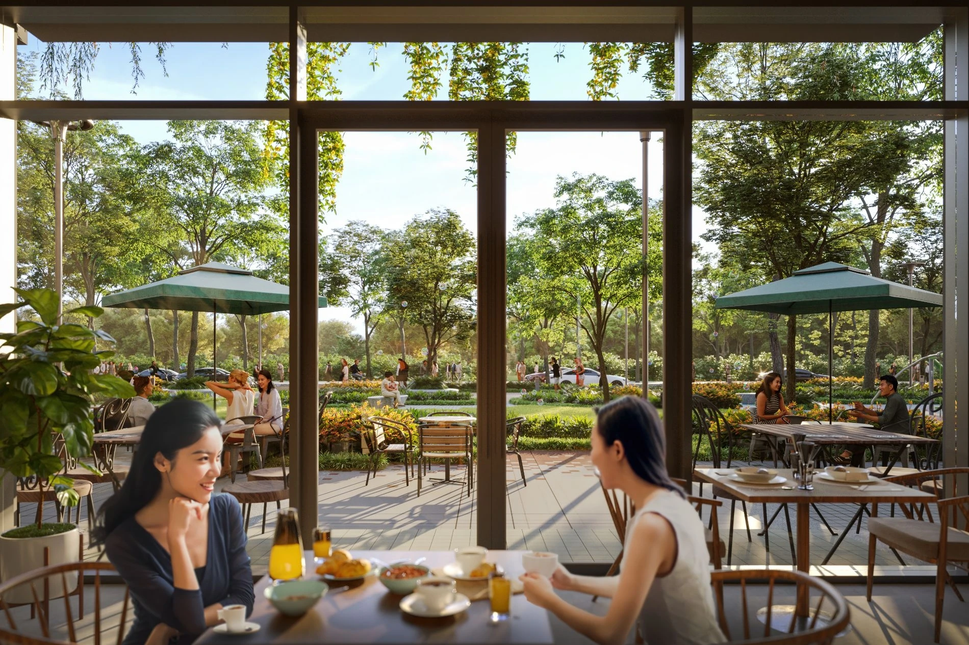 Hai người phụ nữ trò chuyện vui vẻ bên bàn tiệc tại nhà hàng có view nhìn ra công viên Artisan Park