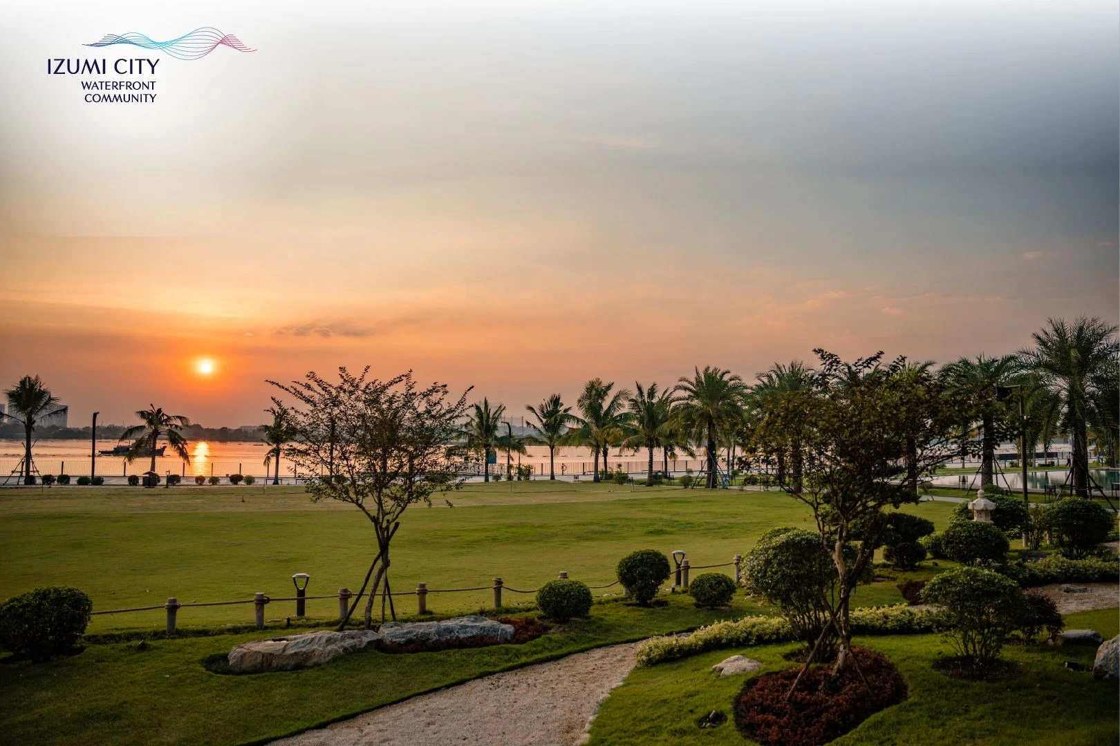 Bãi cỏ xanh mướt tại công viên ven sông khi mặt trời lặn